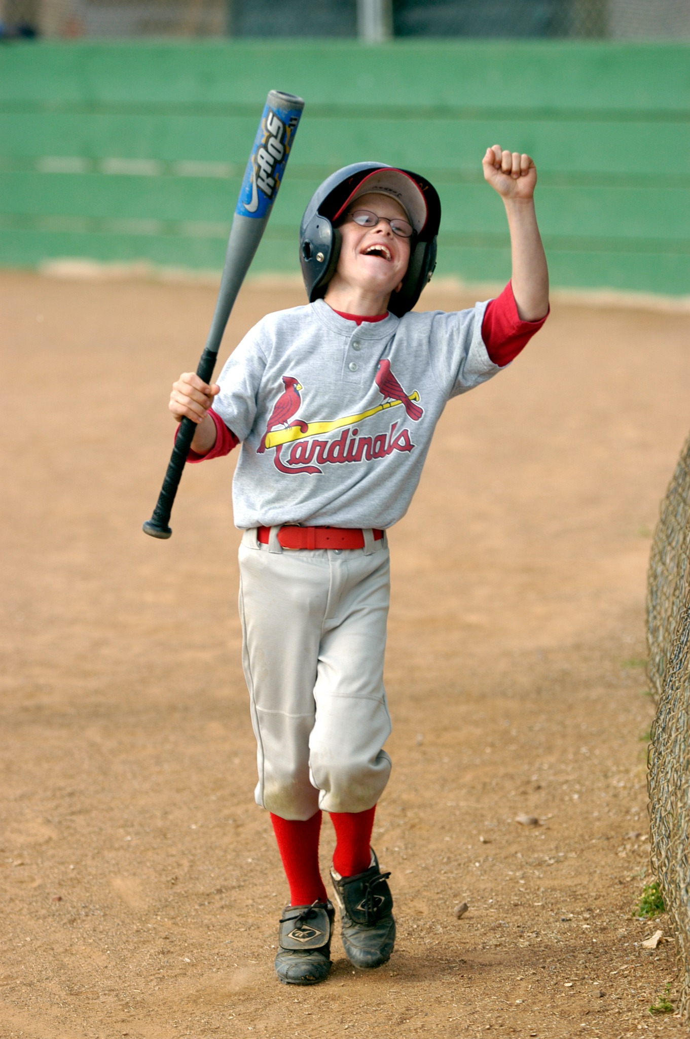 Young baseball player celebrating with bat in hand